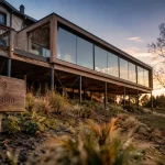 Extension maison sur pilotis sur terrain en pente, au golden hour